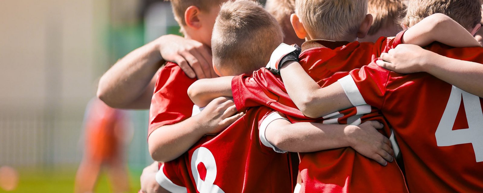Fußball Kinder die sich im Arm halten