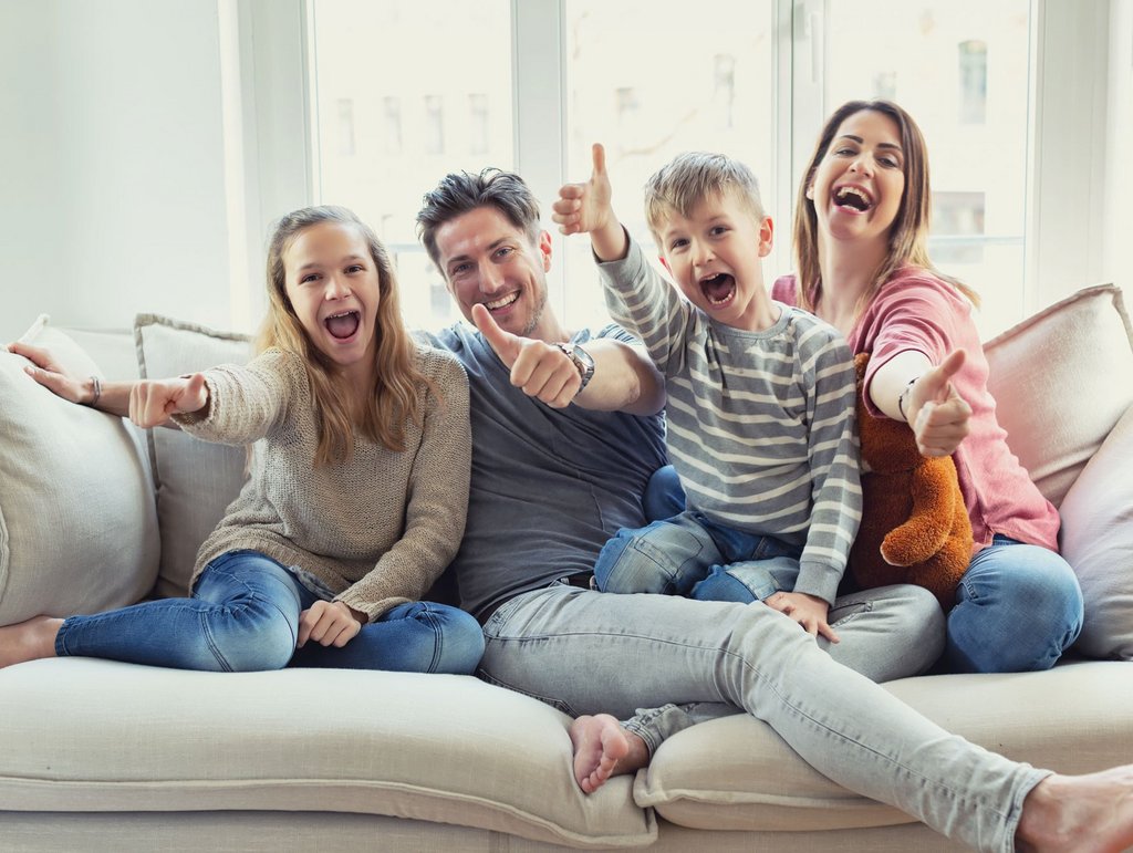 Imagebild, Familie auf Sofa die Daumen nach oben zeigen