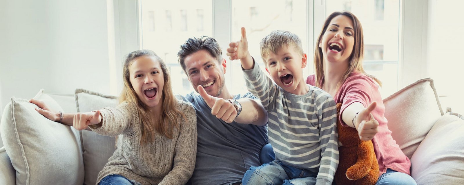 Imagebild, Familie auf Sofa die Daumen nach oben zeigen