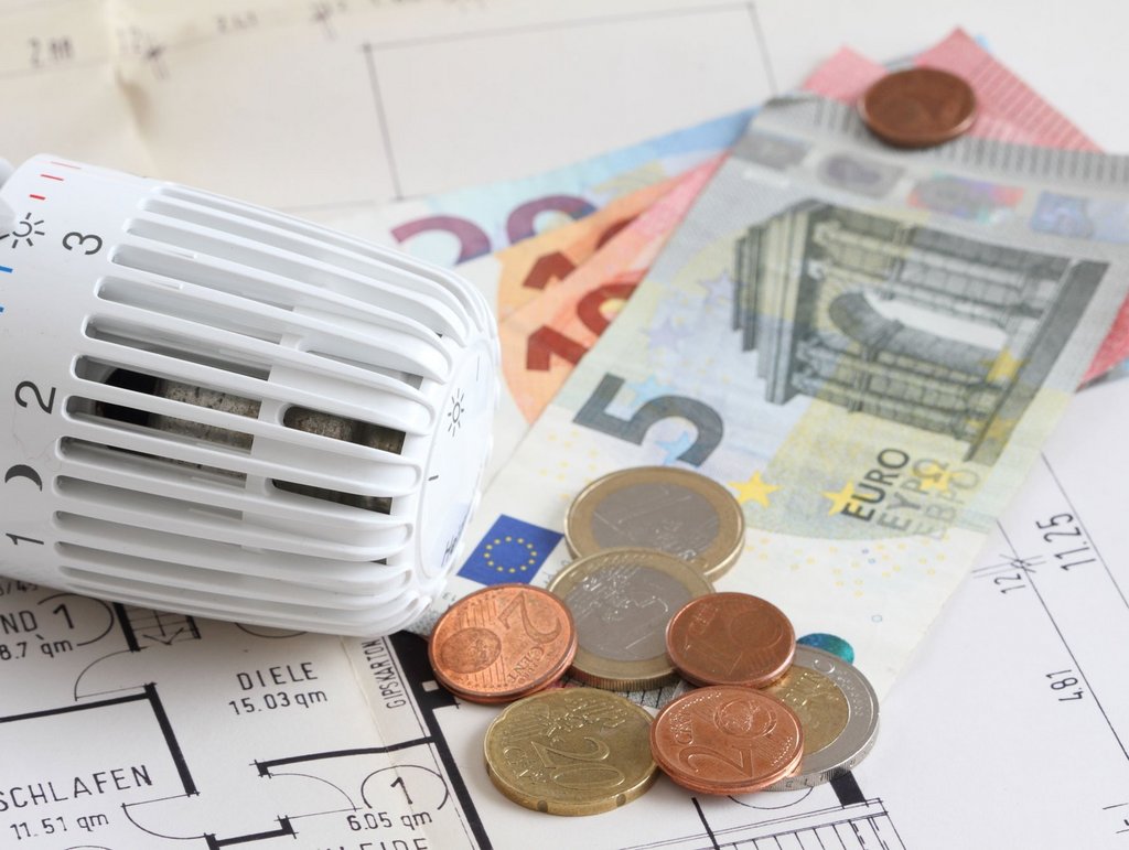 Heizungsthermostat und Geldscheine und Münzen 