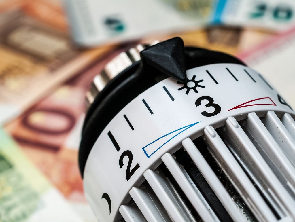 Thermostat an Heizung mit Geld im Hintergrund