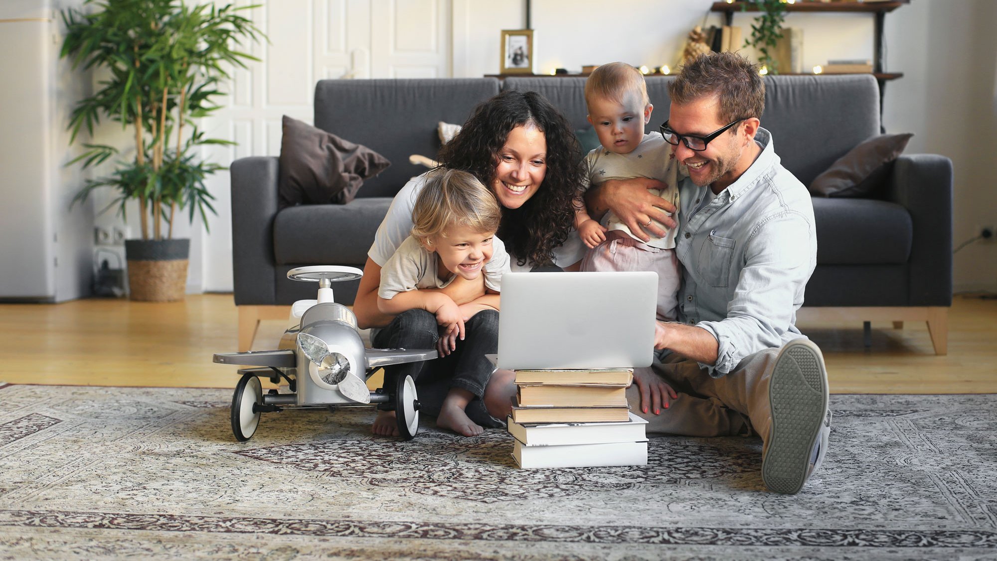 Familie mit zwei kleinen Kindern am Laptop