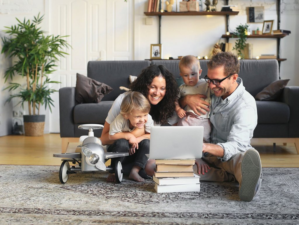 Familie mit zwei kleinen Kindern am Laptop