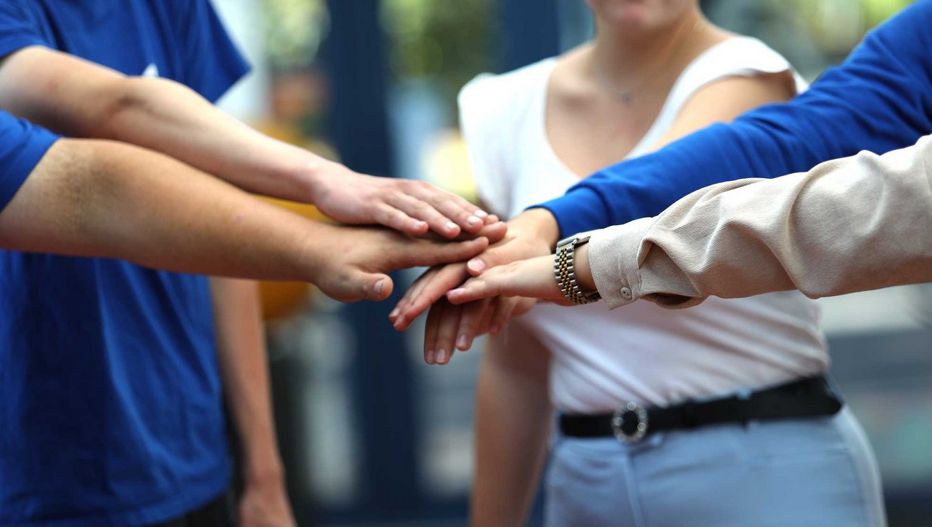 Hände die sich aufeinander legen