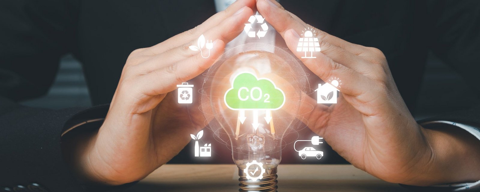 Imagebild: Hand über einer Glühbirne mit Energiesymbolen