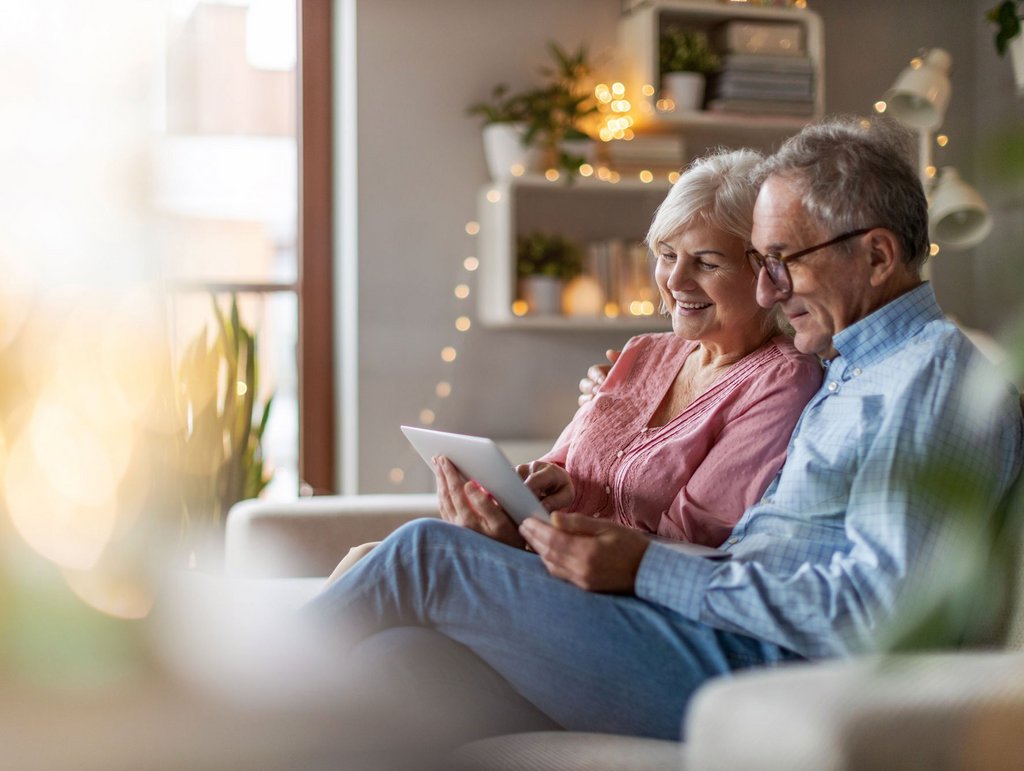 Älteres Ehepaar auf dem Sofa mit Tablet